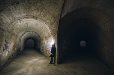 Spanien, Mann lehnt an einer Wand an einer Gabelung zweier Tunnel - RAEF000276