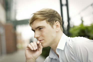 Young man with hand on chin, portrait - GDF000843