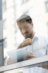 Portrait of businessman looking at digital tablet - PESF000004