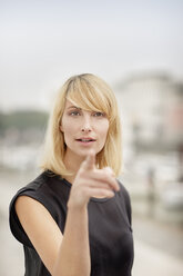 Portrait of blond woman pointing on viewer - PESF000009