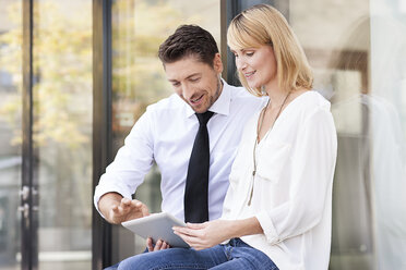 Two business partners sitting side by side with digital tablet - PESF000020