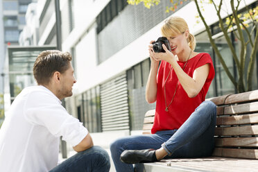 Frau, die ihren Freund mit einer Kamera fotografiert - PESF000025