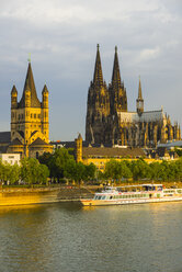 Deutschland, Köln, Blick auf Groß St. Martin, Kölner Dom, Altstadt am Fluss, Rhein am Abend - WGF000693