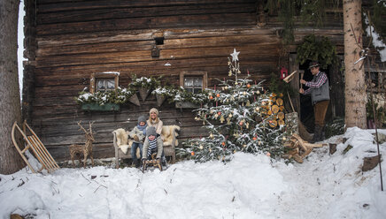 Austria, Altenmarkt-Zauchensee, family in front of farmhouse at Christmas time - HHF005399