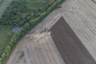 Germany, aerial view of combine harvester at work on a field - PVCF000578