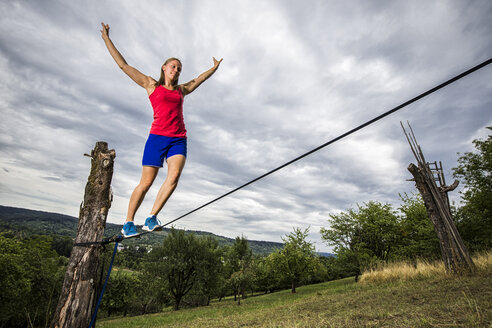 Junge Frau balanciert auf Slackline - STSF000854