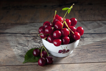 Bowl of sour cherries on wood - CSF026088