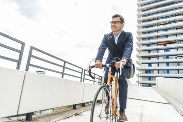 Businessman riding bicycle - UUF005336