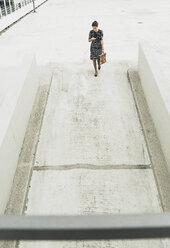 Young businesswoman walking on parking deck - UUF005341