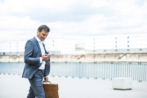 Businessman talking on the phone wearing headset - UUF005232