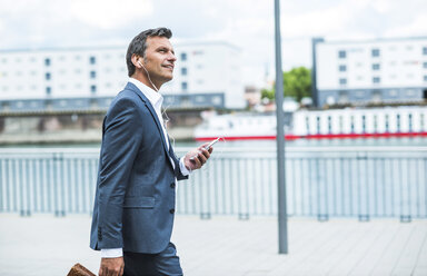 Businessman talking on the phone wearing headset - UUF005234