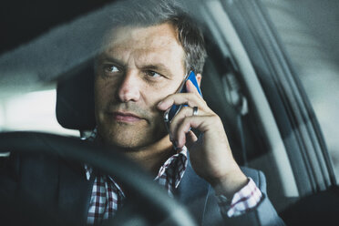 Mature businessman using smart phone in the car - UUF005250