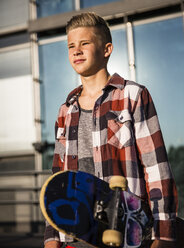 Confident teenager holding skateboard - AIF000015