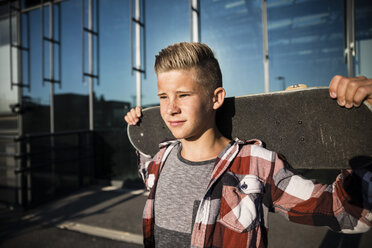 Confident teenager holding skateboard - AIF000016