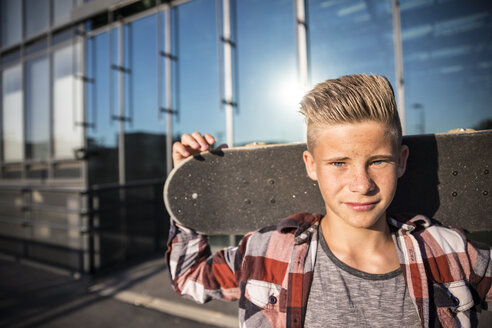 Portrait of teenager holding skateboard - AIF000018