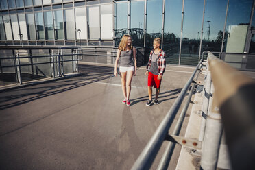 Two teenagers walking on pedestrian bridge - AIF000040