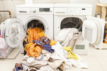 Schmutzige Wäsche fließt aus Waschmaschine und Trockner - JUNF000415