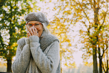 Portrait of laughing woman in an autumnal park - CHAF001133