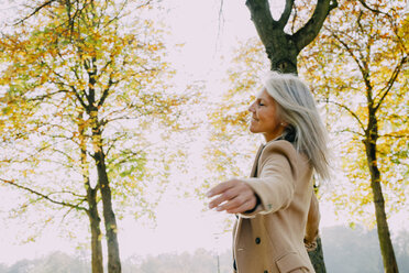 Woman enjoying day at autumnal park - CHAF001071