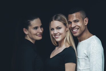 Gruppenbild von zwei jungen Frauen und einem jungen Mann vor einem schwarzen Hintergrund - CHAF001211