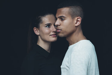 Portrait of young couple head to head in front of black background - CHAF001212
