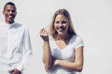 Portrait of laughing blond woman and young man standing in the background - CHAF001227