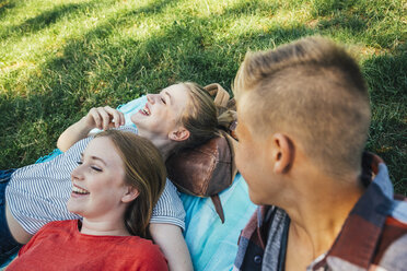 Three teenage friends relaxing in meadow - AIF000062