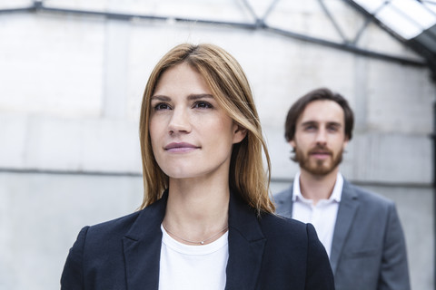 Porträt einer Geschäftsfrau mit ihrem Partner im Hintergrund, lizenzfreies Stockfoto