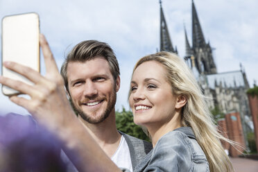 Germany, Cologne, young couple taking a selfie with smartphone - FMKF001761