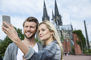 Deutschland, Köln, junges Paar macht ein Selfie mit Smartphone - FMKF001762