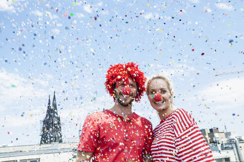 Germany, Cologne, young couple celebrating carnival dressed up as clowns - FMKF001787