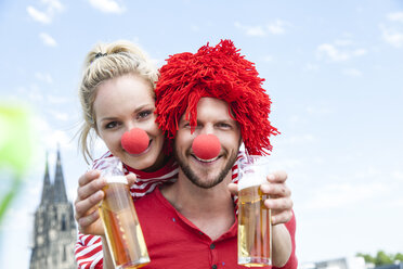 Germany, Cologne, young couple celebrating carnival dressed up as clowns - FMKF001789