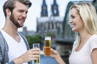 Germany, Cologne, happy young couple with Koelsch glasses - FMKF001800