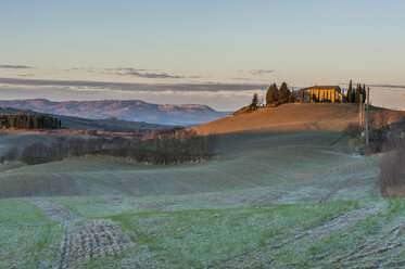 Italien, Toskana, Val d'Orcia, Blick auf Landschaft mit Wohnhaus auf einem Hügel - LOMF000051