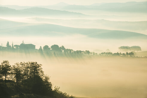Italien, Toskana, San Quirico d'Orcia, Blick auf hügelige Landschaft bei Sonnenaufgang im Nebel - LOMF000037