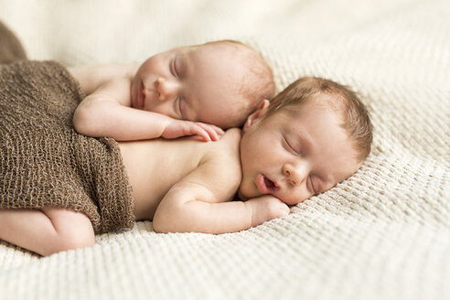 Neugeborene Zwillinge mit einem Tuch zugedeckt auf einer Decke schlafend - SHKF000340