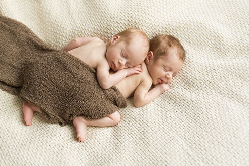 Neugeborene Zwillinge mit einem Tuch zugedeckt auf einer Decke schlafend - SHKF000339