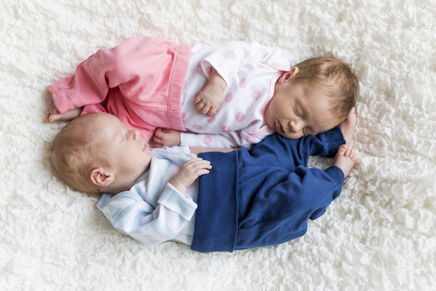 Neugeborene Zwillinge schlafen auf einer weißen Decke, lizenzfreies Stockfoto