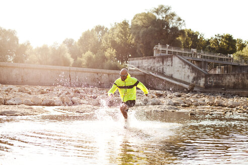 Mann in Sportkleidung läuft im Wasser - MAEF010863