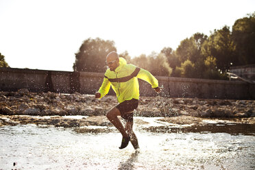 Man in sports wear running in water - MAEF010907