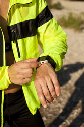 Mann in Sportkleidung stellt seine Smartwatch ein - MAEF010865