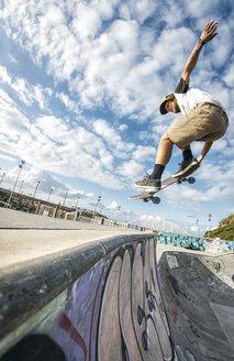 Junger Skateboarder, der in einem Skatepark in die Luft springt - MGOF000419