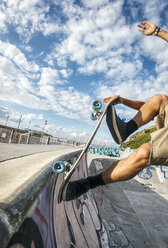 Beine eines jungen Mannes beim Skateboarden in einem Skatepark - MGOF000425