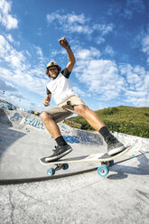 Junger Mann auf dem Skateboard in einem Skatepark - MGOF000426