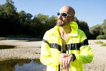 Mann in Sportkleidung stellt seine Smartwatch ein - MAEF010875