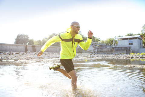 Mann in Sportkleidung läuft im Wasser, lizenzfreies Stockfoto