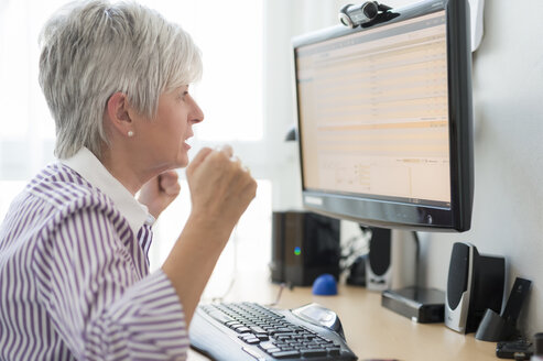 Senior woman looking horrified at computer monitor - FRF000309