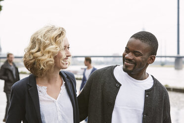 Happy young couple going for a walk at the riverside - STKF001371