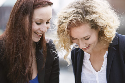 Zwei junge Frauen lachen im Freien - STKF001388