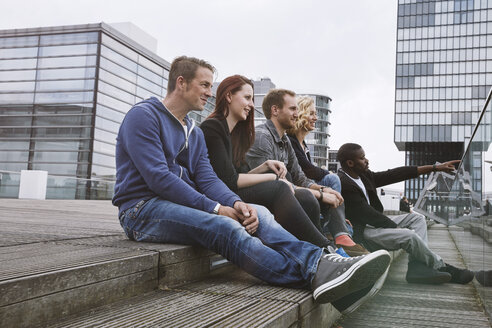 Gruppe von Freunden sitzt im Freien auf einer Treppe - STKF001398